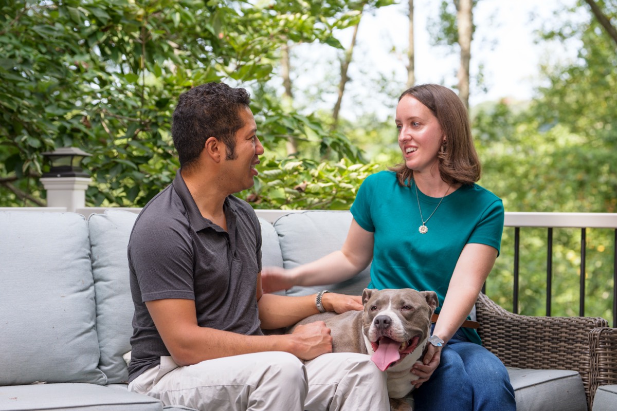 Brittany and Fernando on their back deck with their rescue dog Poppy